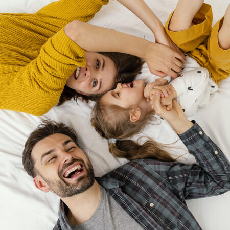 genitori-di-tiro-medio-e-bambino-letto-vista-dall-alto